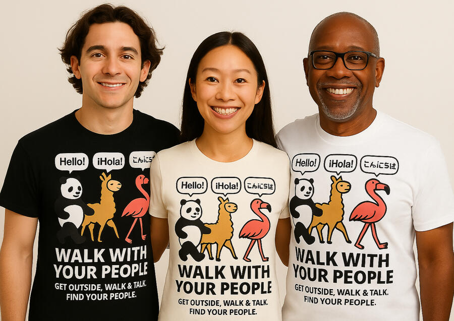 A diverse group of smiling people wearing “Walk With Your People™” t-shirts, standing side by side as part of a global movement to get people outside walking together and building real-world connections.
